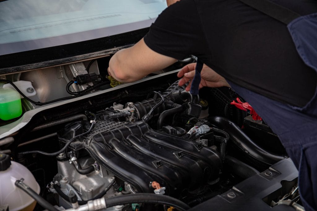 Mechanic checking for mechanical red flags in a used car