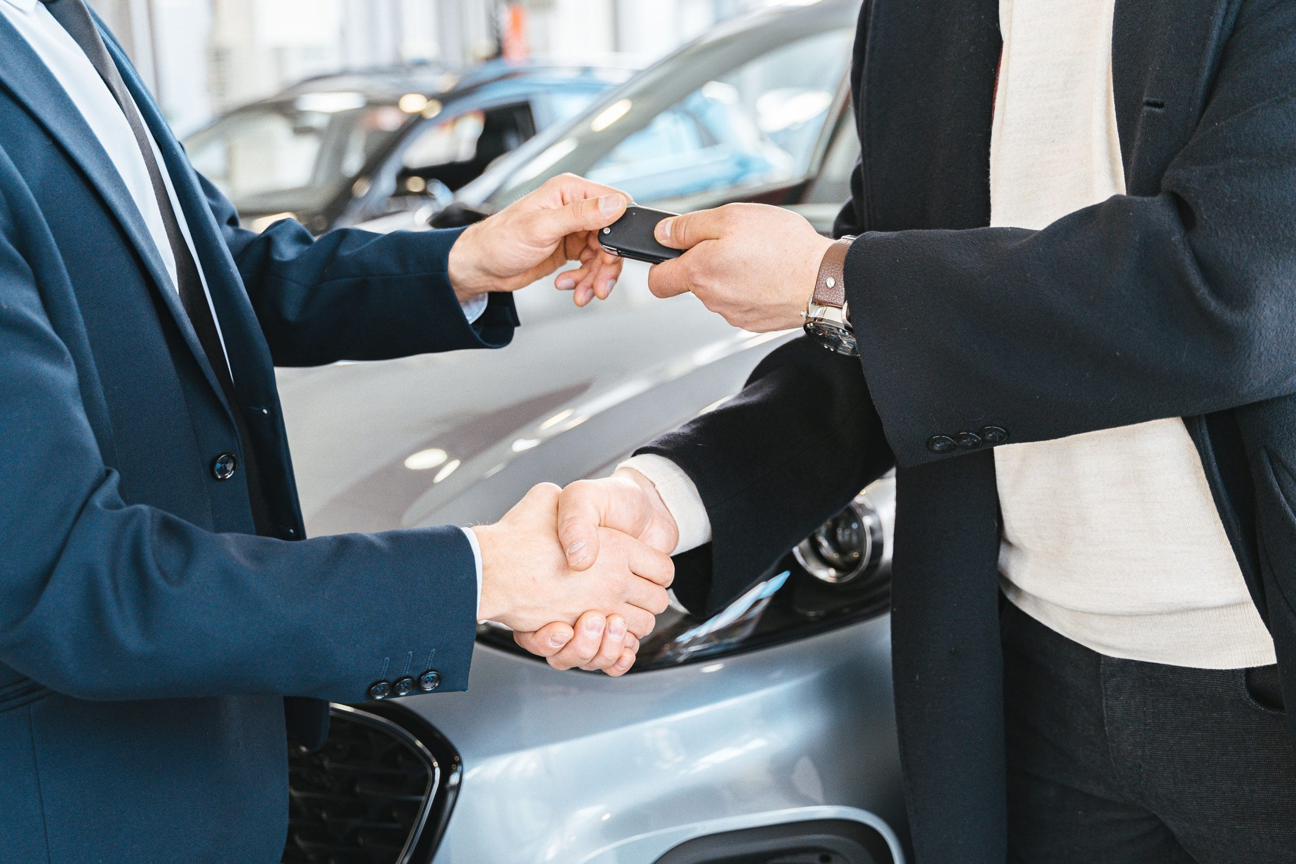 Illustration of a buyer and seller shaking hands over a used car deal, representing successful price negotiation