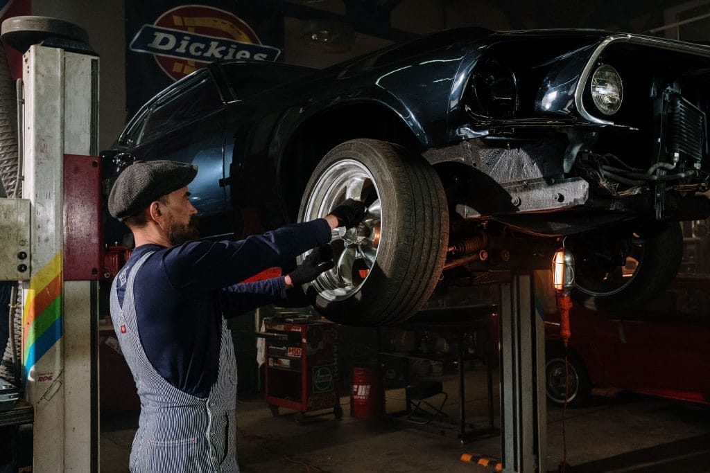 Extend tire life: mechanic rotating car tires