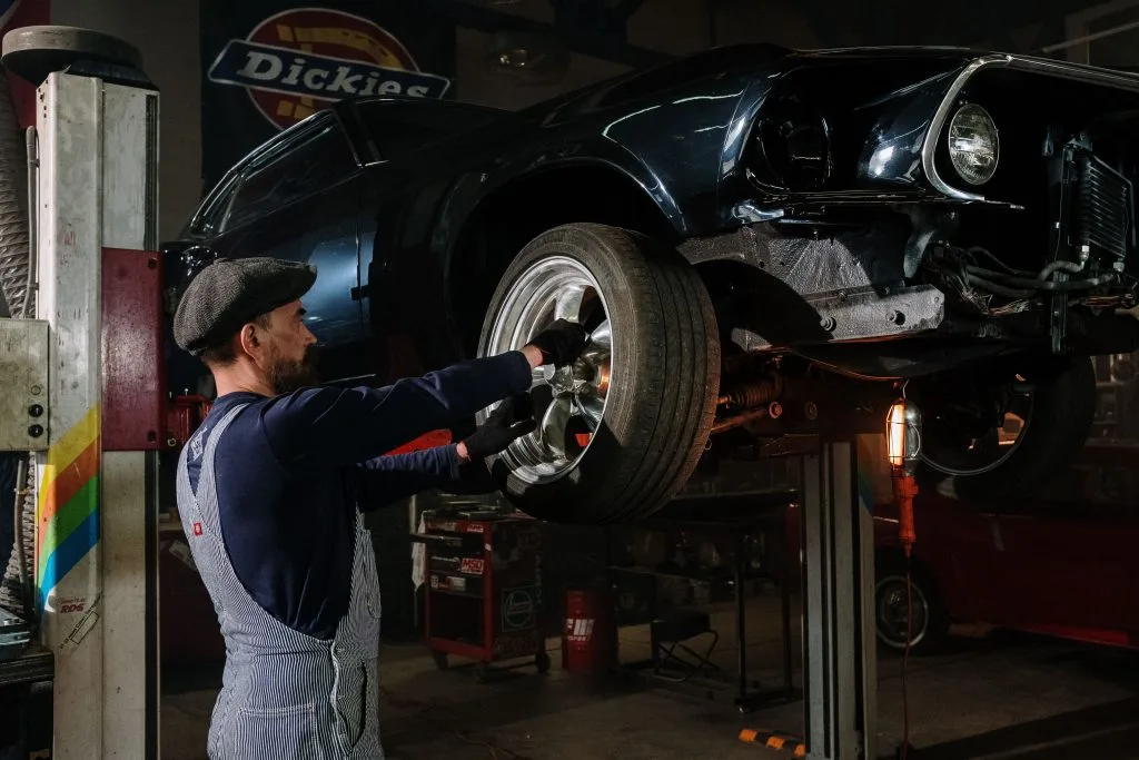 Extend tire life: mechanic rotating car tires