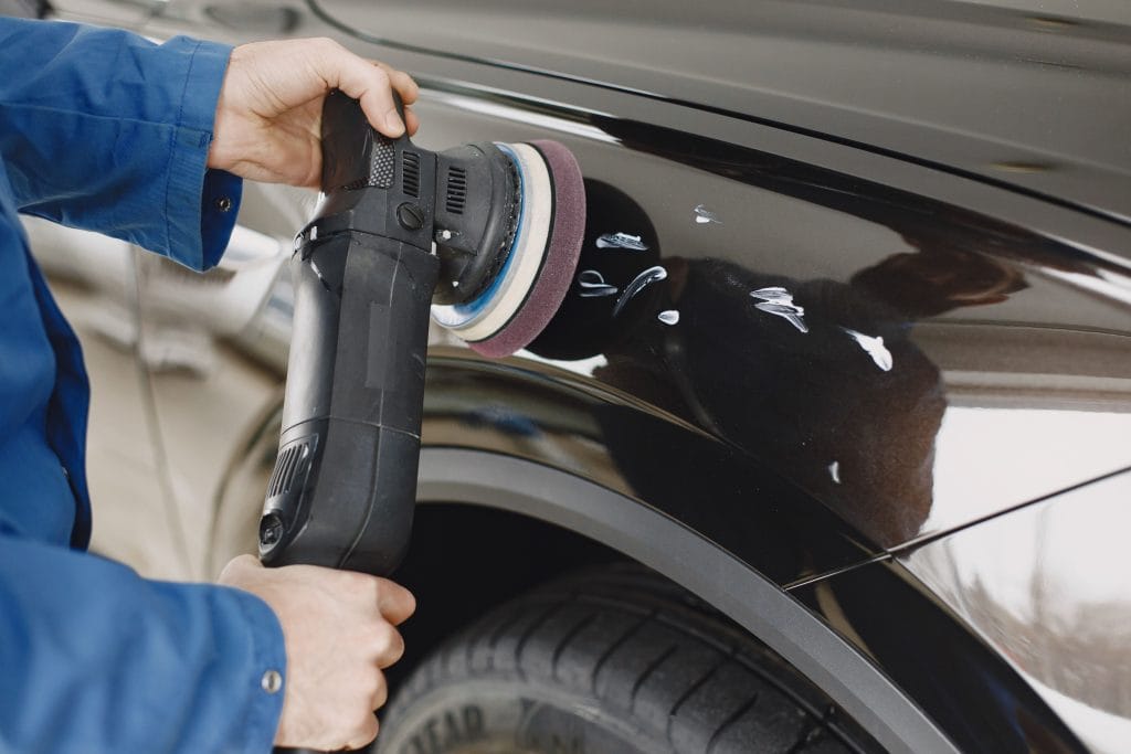 Checking used car exterior for scratches and dents
