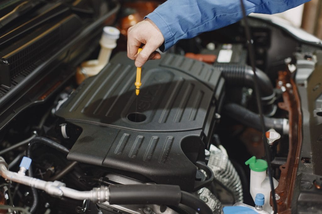 Mechanic inspecting used car engine before purchase