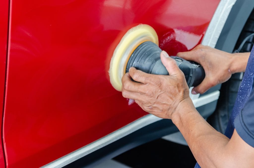 Checking used car exterior for scratches and dents