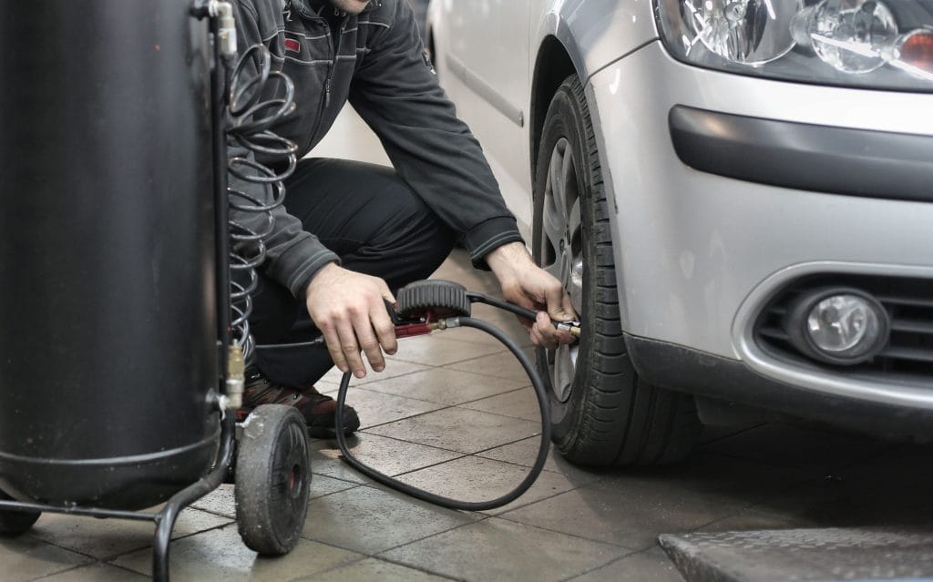 Extend tire life: checking tire pressure with gauge
