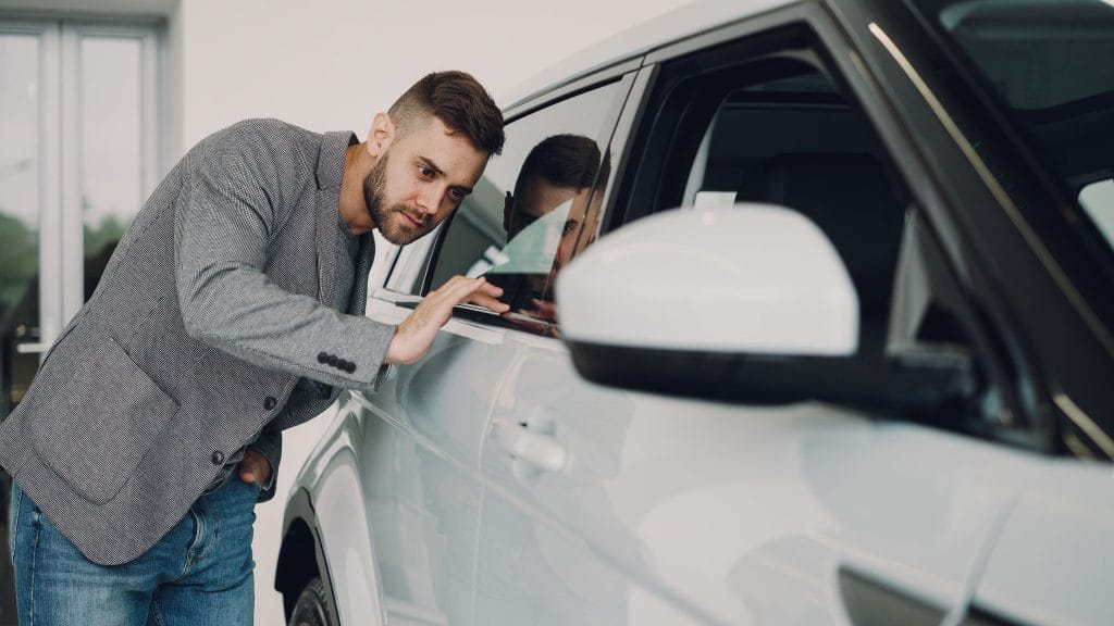 First-time car buyer comparing options before choosing their first car