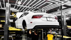 Technician performing a certified pre-owned multi-point inspection before a used car is certified