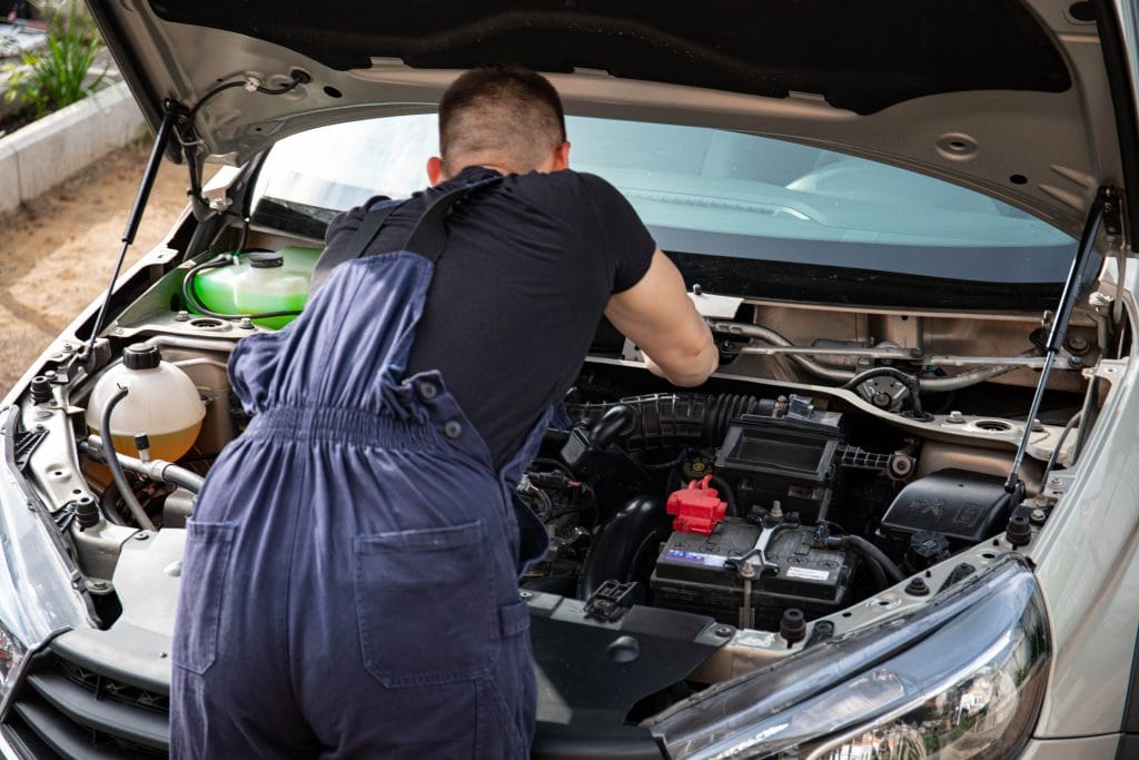 Car's Warranty and Service Packages: mechanic performing scheduled maintenance
